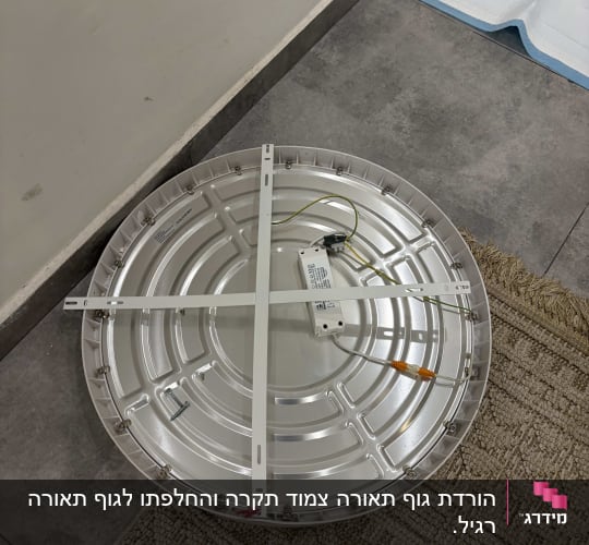 מנורה עגולה עם חוטי חשמל על הרצפה